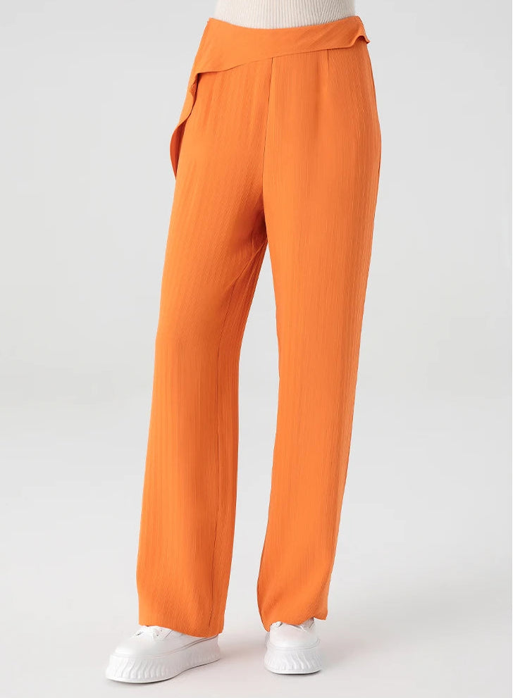 A woman wearing high-density Mulberry silk jacquard tapered trousers in Fragrant Cloud orange gradient, front view — From Borcelleclothes.
