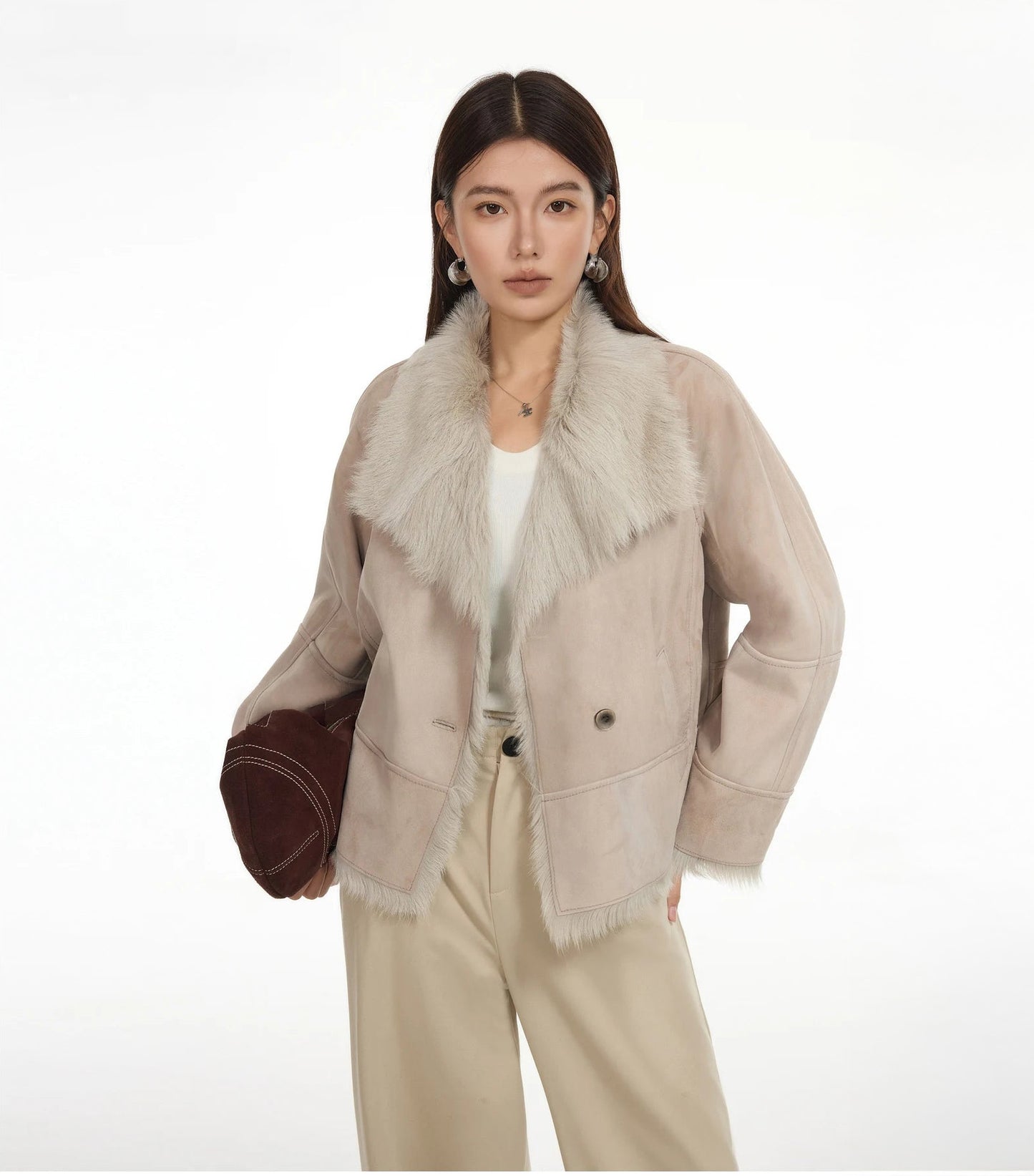 Model holding bag at hip, other hand at hip, suede-faced goatskin jacket in Fond Memory — From Borcelleclothes.