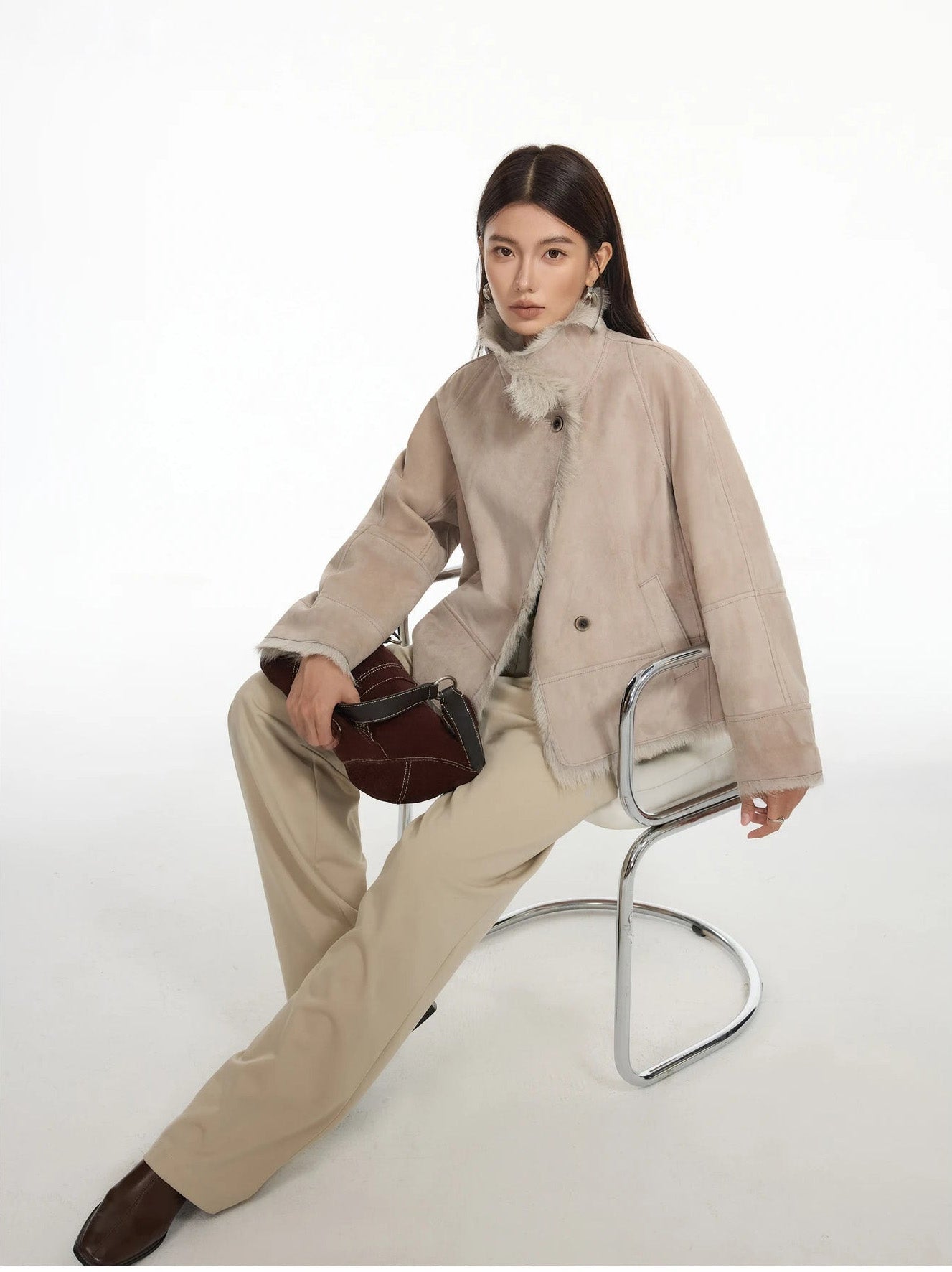Model seated on chair in suede-faced goatskin jacket in Fond Memory — From Borcelleclothes.