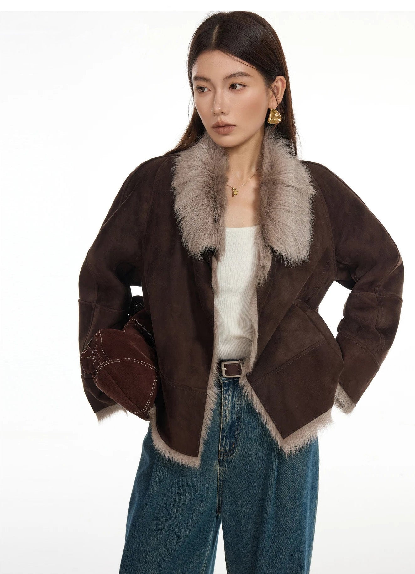 Woman holding bag at hip, wearing suede-faced goatskin jacket in Toorak — From Borcelleclothes.