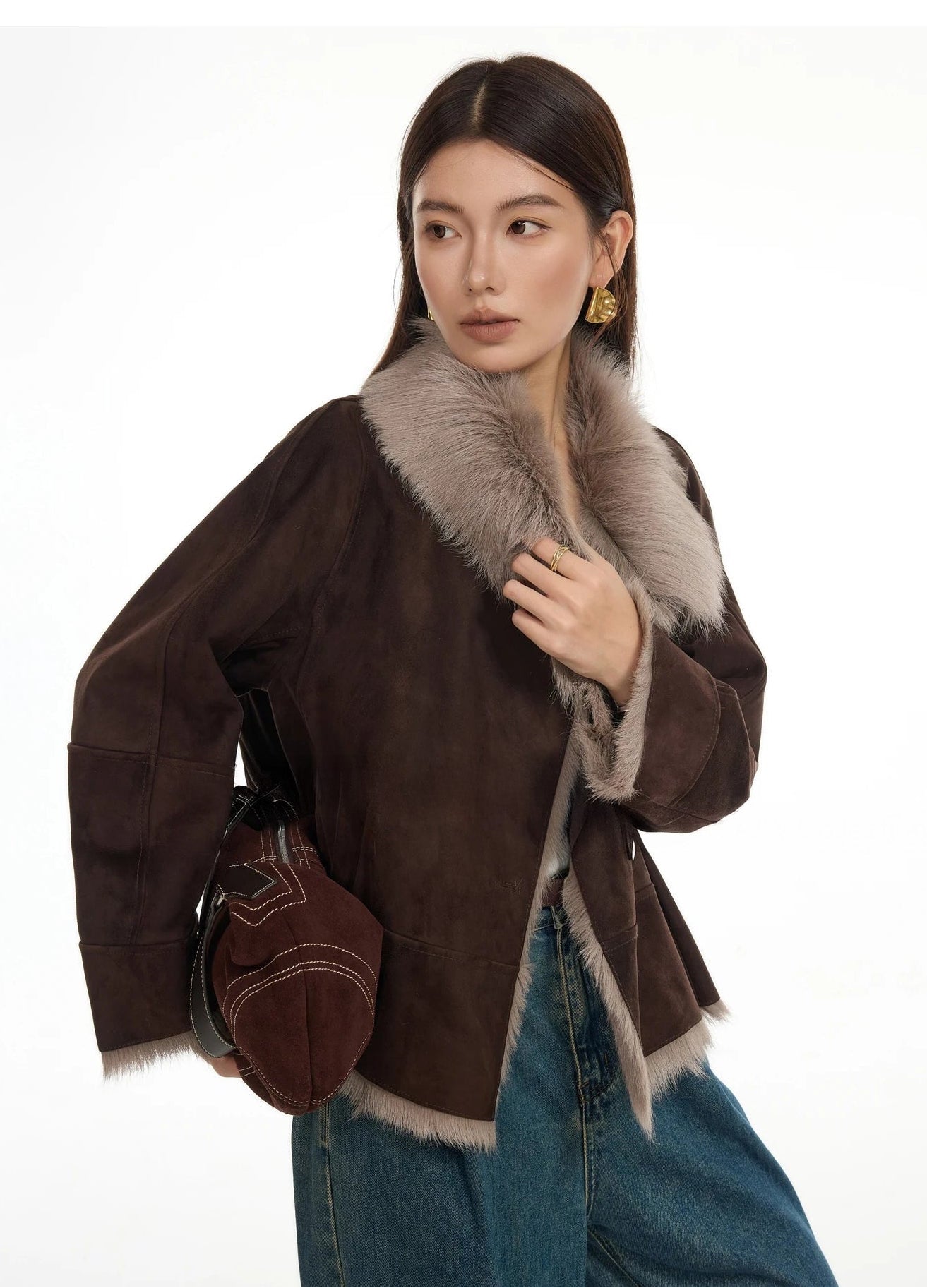 Model touching collar of suede-faced goatskin jacket in Toorak, highlighting exposed wool — From Borcelleclothes.