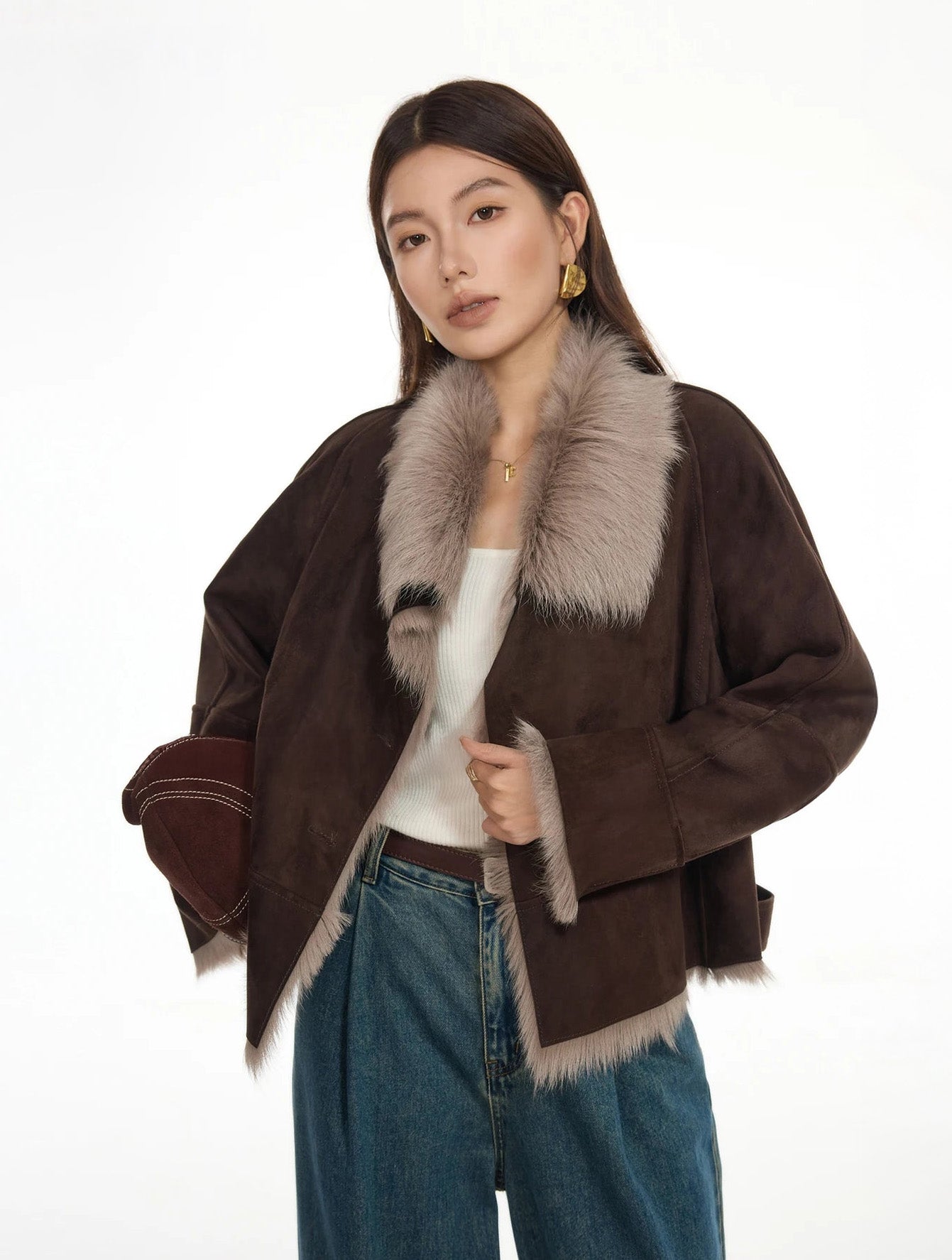 Woman holding the front edge of unfastened suede-faced goatskin jacket in Toorak — From Borcelleclothes.