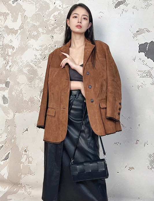 Model touching the lapel of a suede goatskin blazer in Sand Dance — From Borcelleclothes.