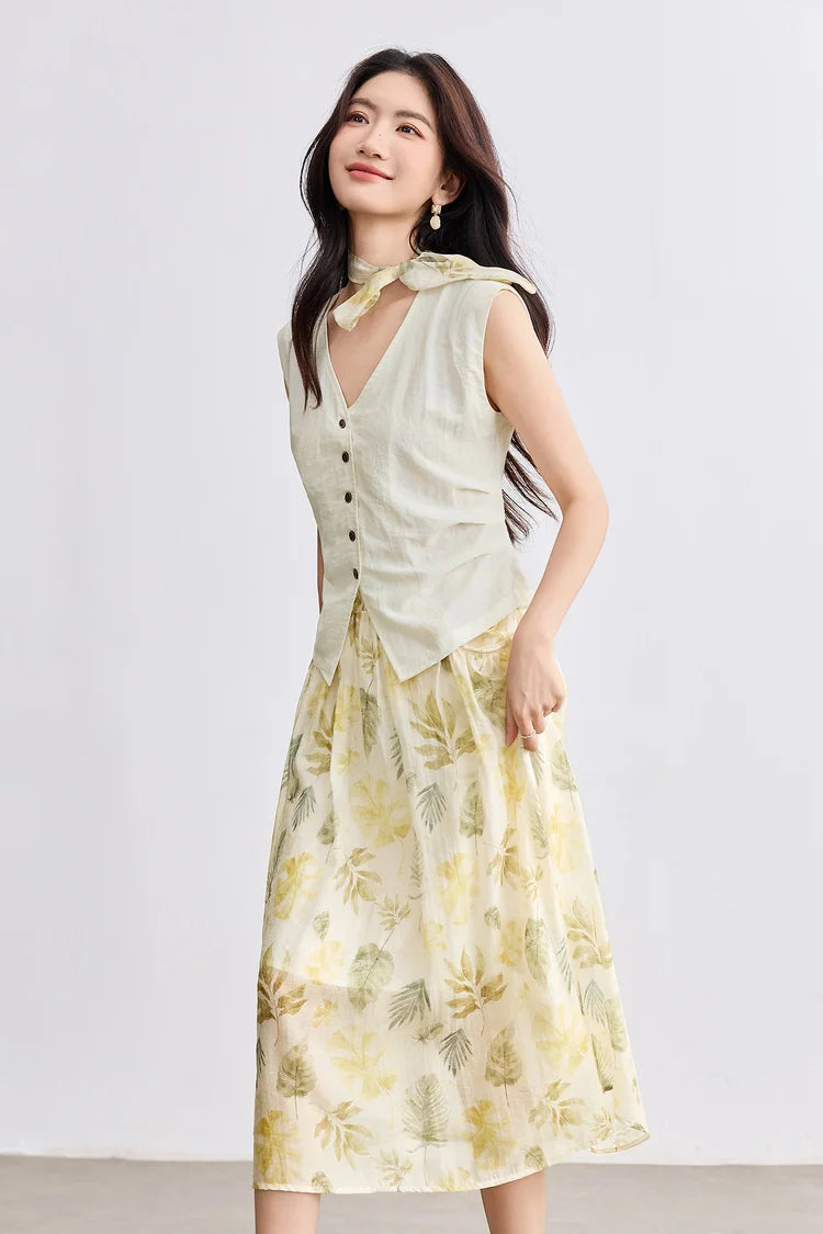 Side profile of a woman walking and gently touching the printed chiffon skirt of the Sydney Breeze set — From Borcelleclothes.