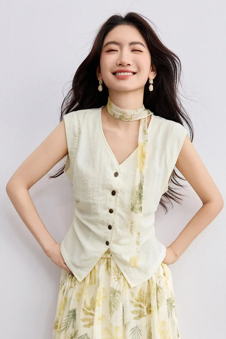 A smiling woman with hands on her hips, highlighting the sail-inspired waist pleats of the Sydney Breeze vest — From Borcelleclothes.