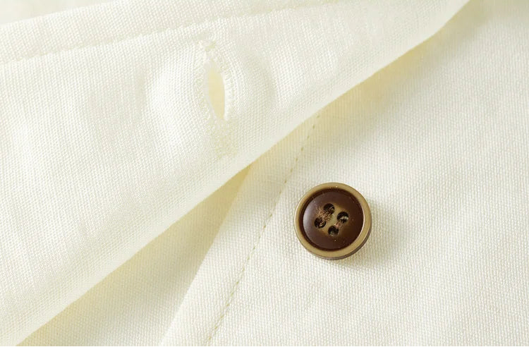 Detail of an unfastened button on the Sydney Breeze vest, revealing the fine weave of the fabric — From Borcelleclothes.