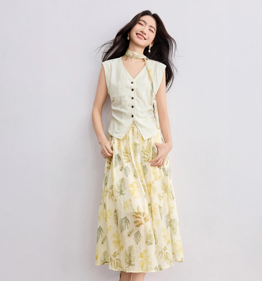 Women's soft yellow Sydney Breeze set featuring a tailored vest with waist pleats and a matching floral chiffon skirt with monstera leaf print. — From Borcelleclothes.