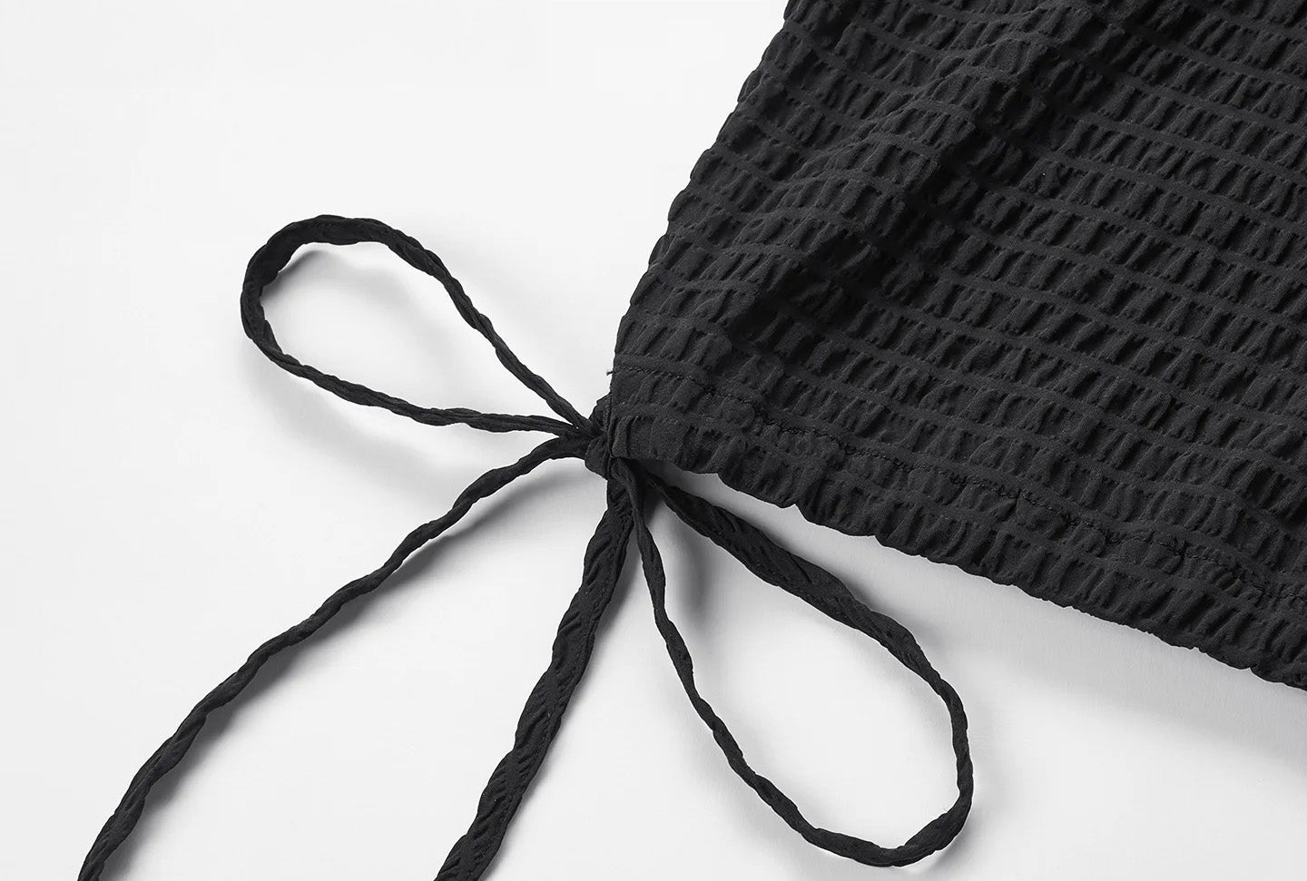 Close-up of the hem casing with a tied drawstring on the side of a black silk blouse — From Borcelleclothes.