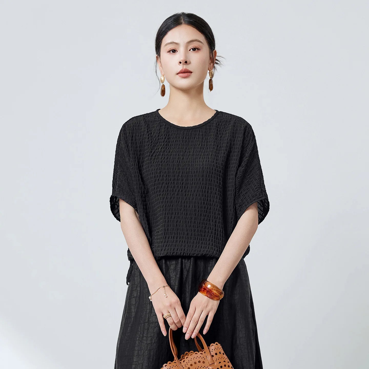 Women's Wrinkle-resistant Mulberry silk blouse in textured 3D stripes and Without Pressure color. Features batwing sleeves, a round neckline, and an adjustable hem. —From Borcelleclothes.