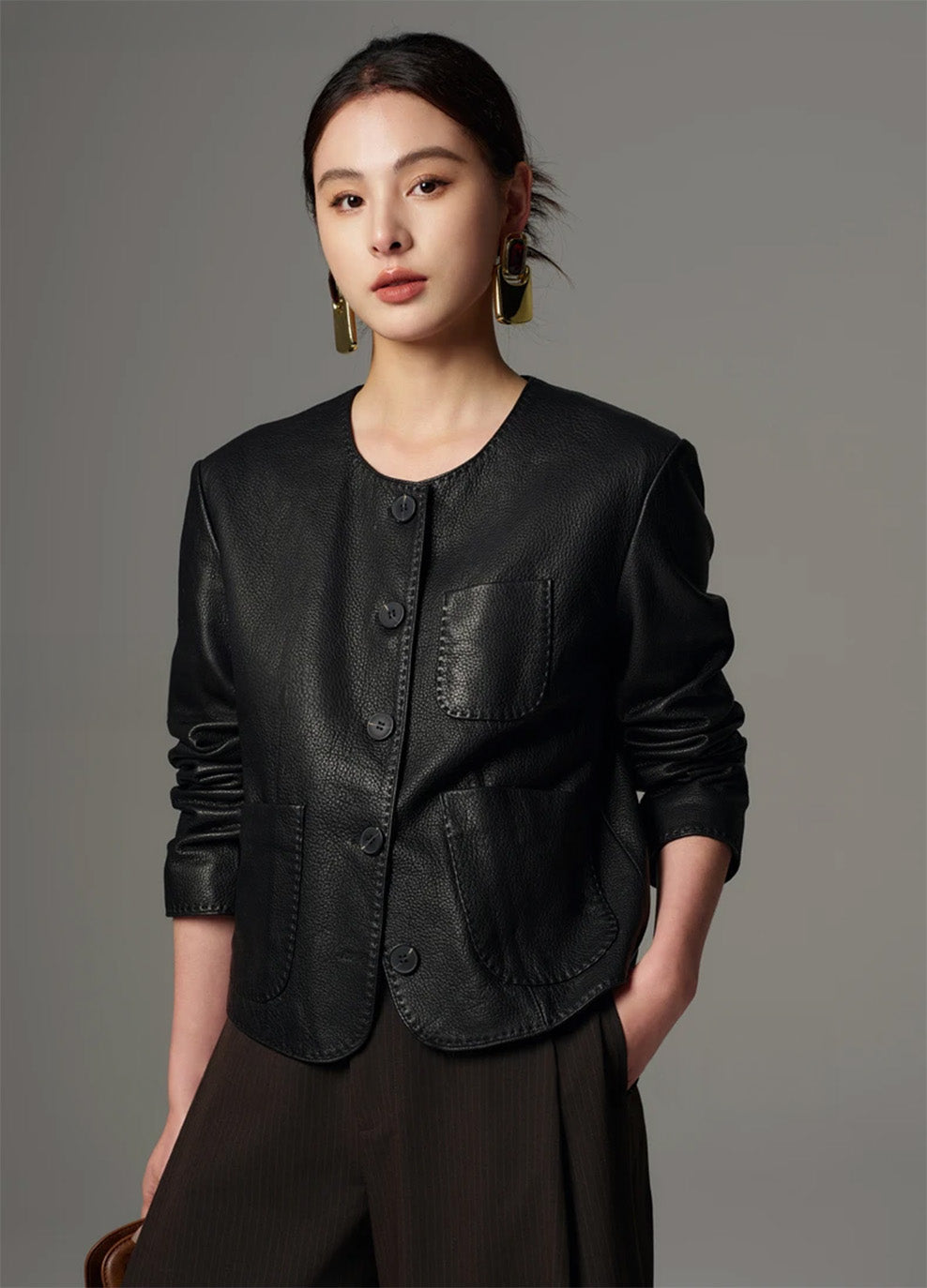 Three-quarter front view of the model wearing the cropped goatskin leather jacket in Calculated Tension — From Borcelleclothes.