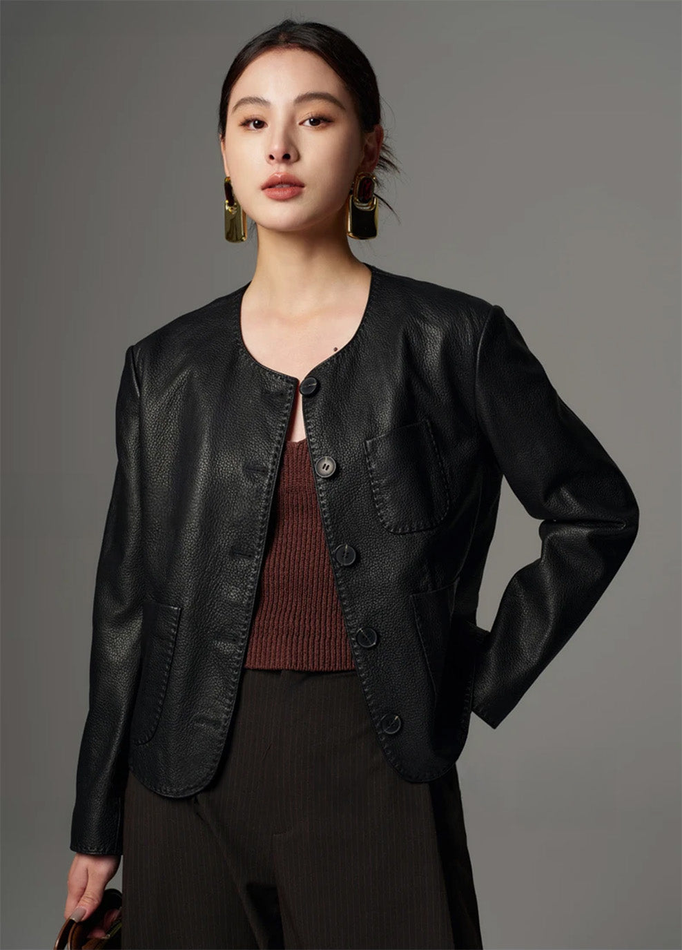 Model posing with one hand on her hip in an unfastened cropped pebble goatskin jacket in Calculated Tension — From Borcelleclothes.