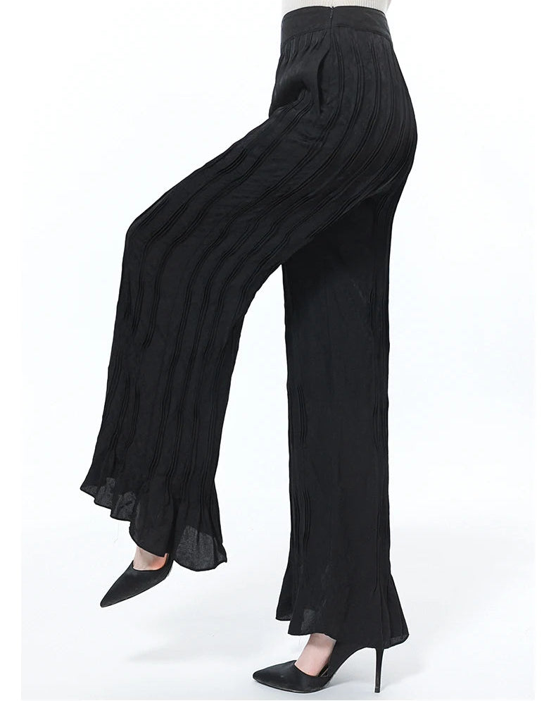Women’s silk jacquard trousers in Hide-and-Seek with an asymmetrical yoke, side view on model with a raised leg — From Borcelleclothes.