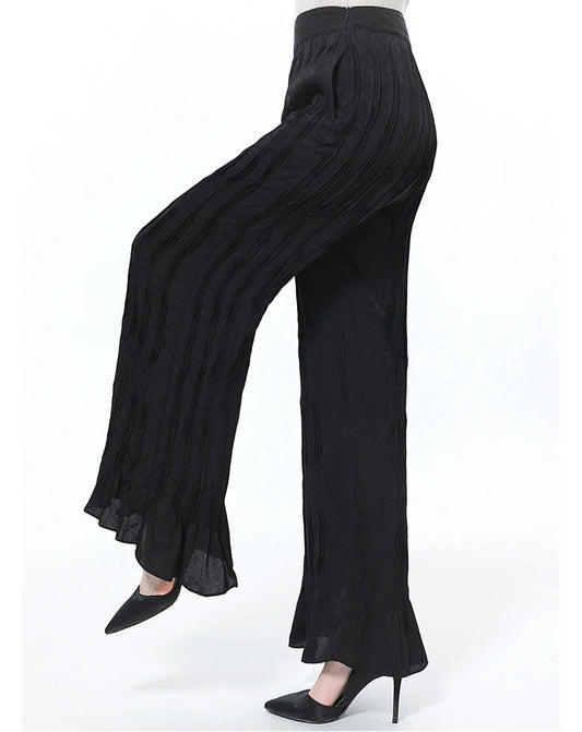 Women’s silk jacquard trousers in Hide-and-Seek with an asymmetrical yoke, side view on model with a raised leg — From Borcelleclothes.