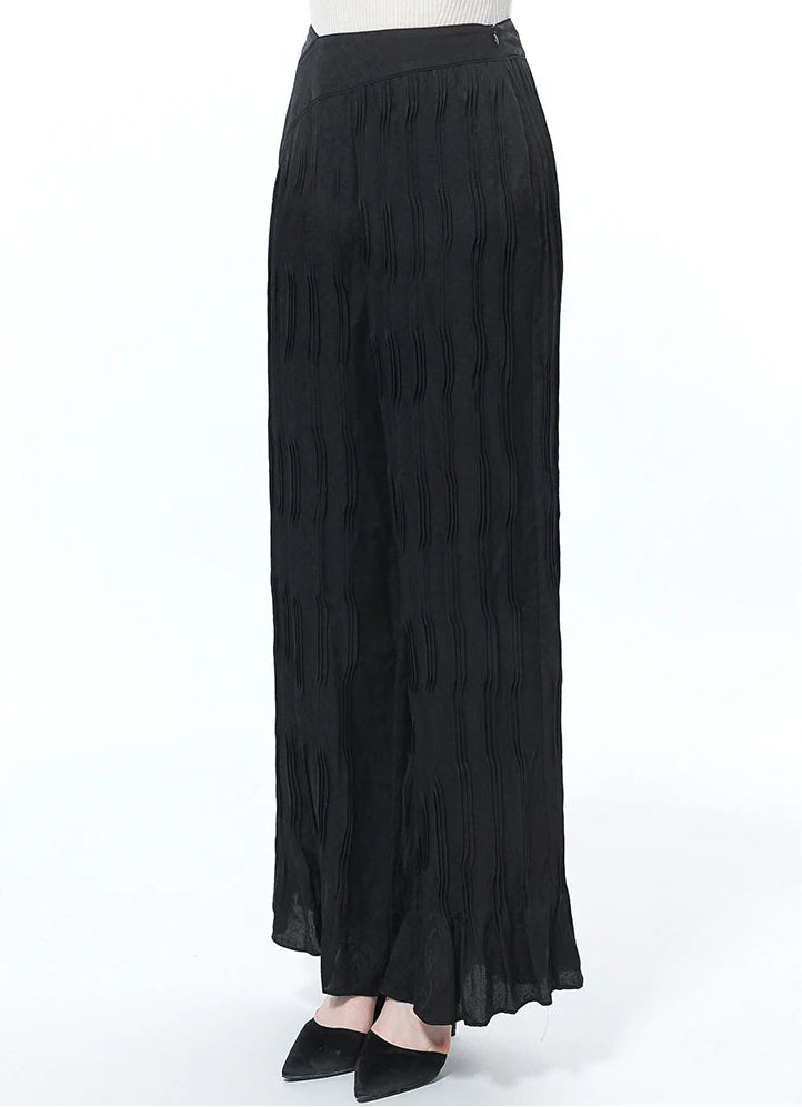 Model standing slightly turned to the side in Hide-and-Seek silk trousers — From Borcelleclothes.