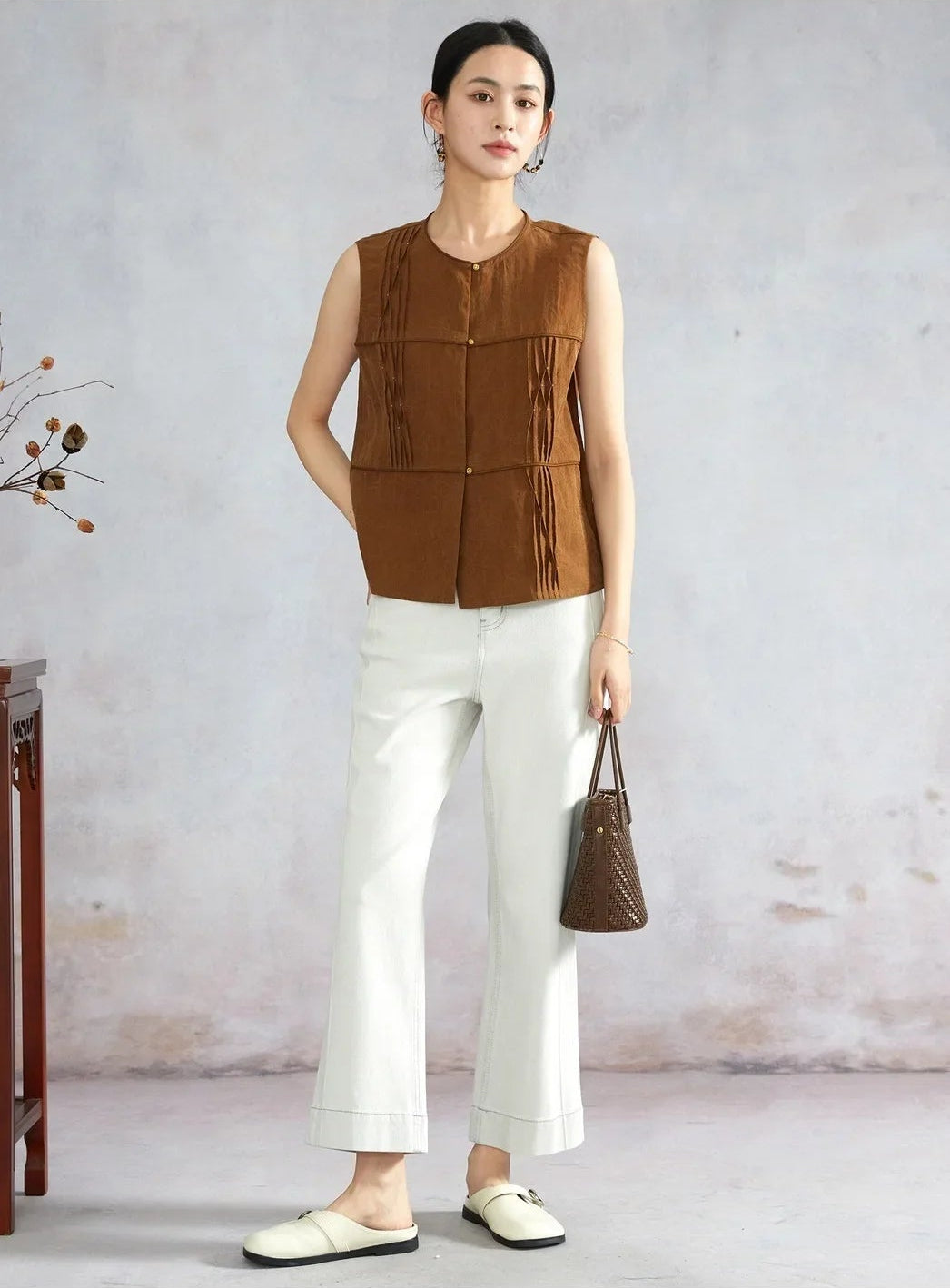 Model posing in Tucked Xiangyunsha Silk Blouse in Cinnamon Amulet holding bag with hand on hip — From Borcelleclothes.