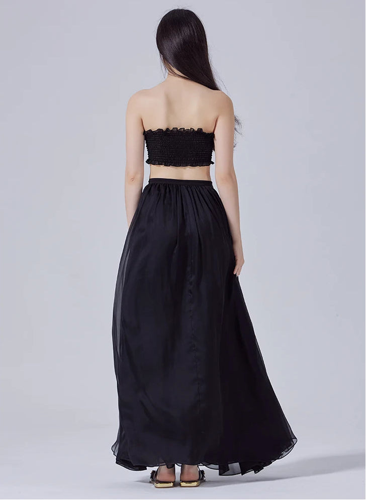 Full-height back view of model wearing two-layer pleated Mulberry silk maxi skirt in Ink Dance — From Borcelleclothes.