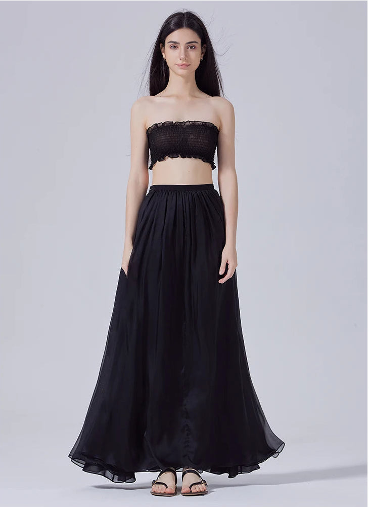 Model standing straight with arms down, wearing women's pleated Mulberry silk maxi skirt — From Borcelleclothes.