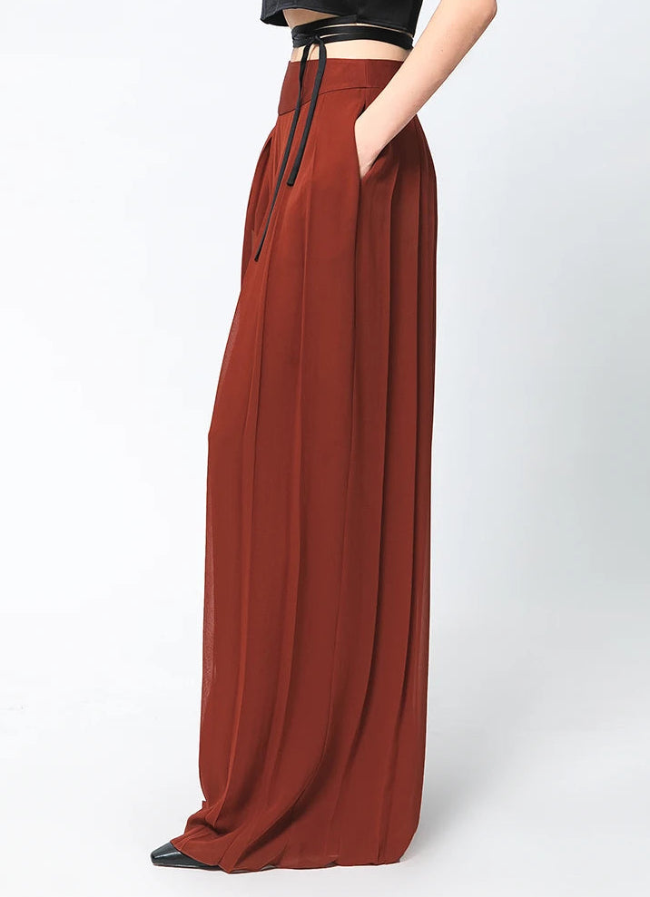 Side profile view of two-layer pleated Mulberry silk georgette trousers in Contradictory Terracotta — From Borcelleclothes.