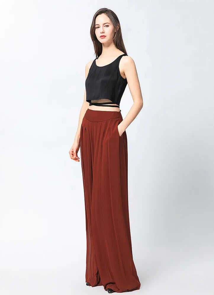 Two-layer pleated Mulberry silk georgette trousers in Contradictory Terracotta, model turned slightly to the side — From Borcelleclothes.