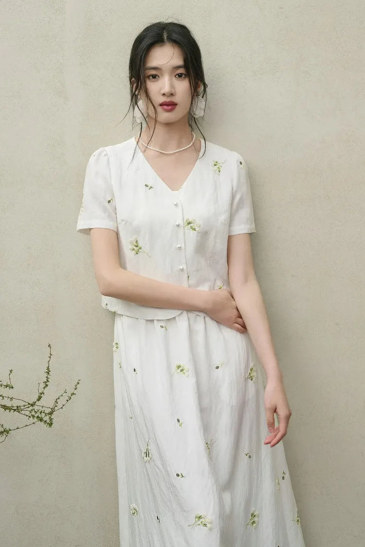 A woman posing in the Utsugi Blossom set with a hand on her hip, emphasizing the cropped fit of the top and the artistry of the Bride’s Silence embroidery — From Borcelleclothes.