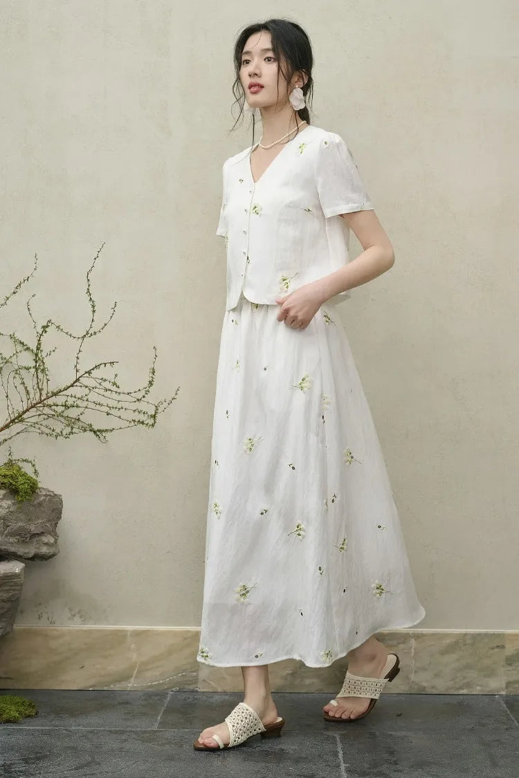 Side view of a woman walking in the flared Utsugi Blossom midi skirt, capturing the rhythmic movement of the Bride’s Silence white fabric — From Borcelleclothes.