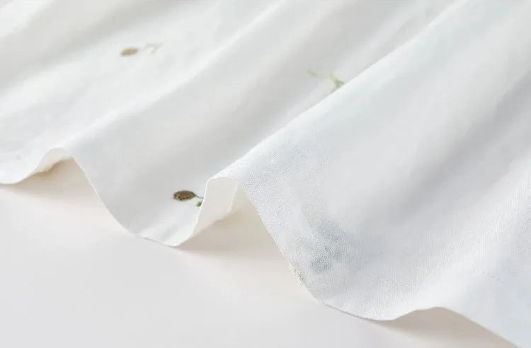 The delicate flared hem of the Utsugi Blossom midi skirt, showing the 3D bloom embroidery in Bride’s Silence white — From Borcelleclothes.