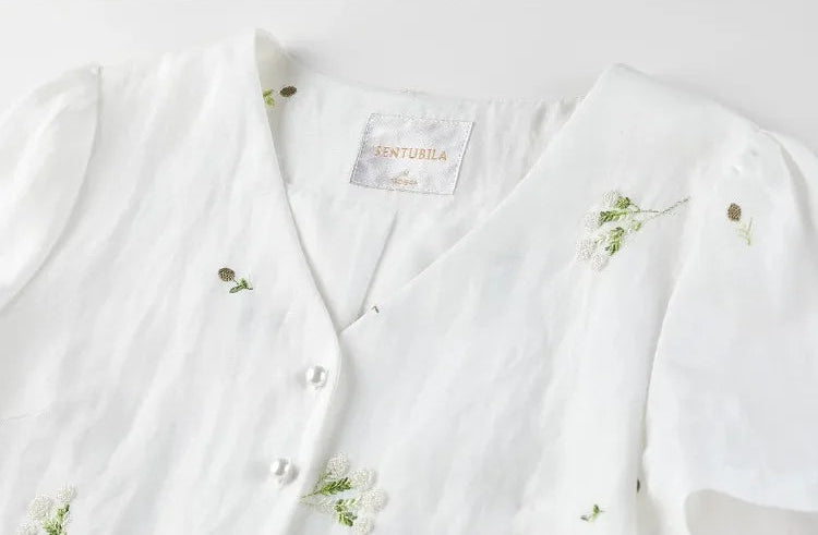 Close-up of the upper part of the Utsugi Blossom top, showing the soft wrap V-neckline and Bride’s Silence white embroidery — From Borcelleclothes.