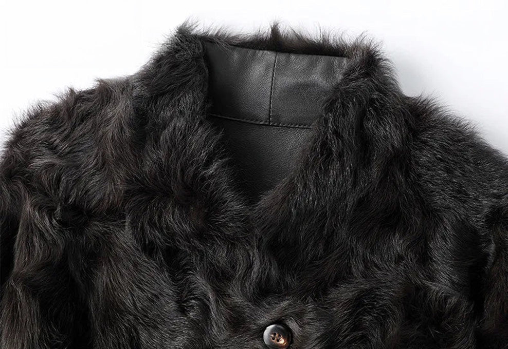 Close detail of the V-shaped neckline collar on the Henna Glow shearling coat — From Borcelleclothes.