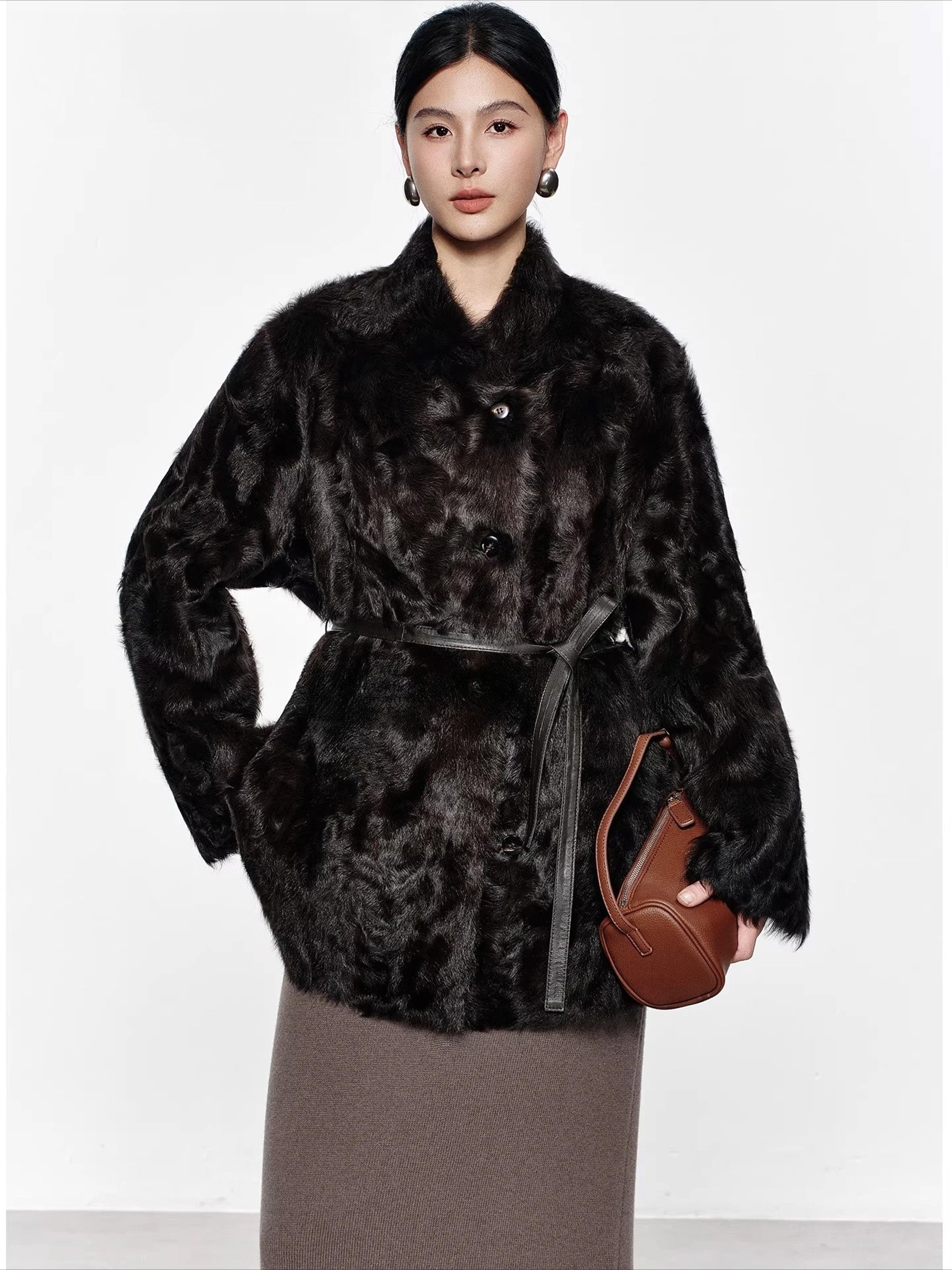 Model wearing the Henna Glow V-shaped neckline shearling coat while holding a brown handbag — From Borcelleclothes.