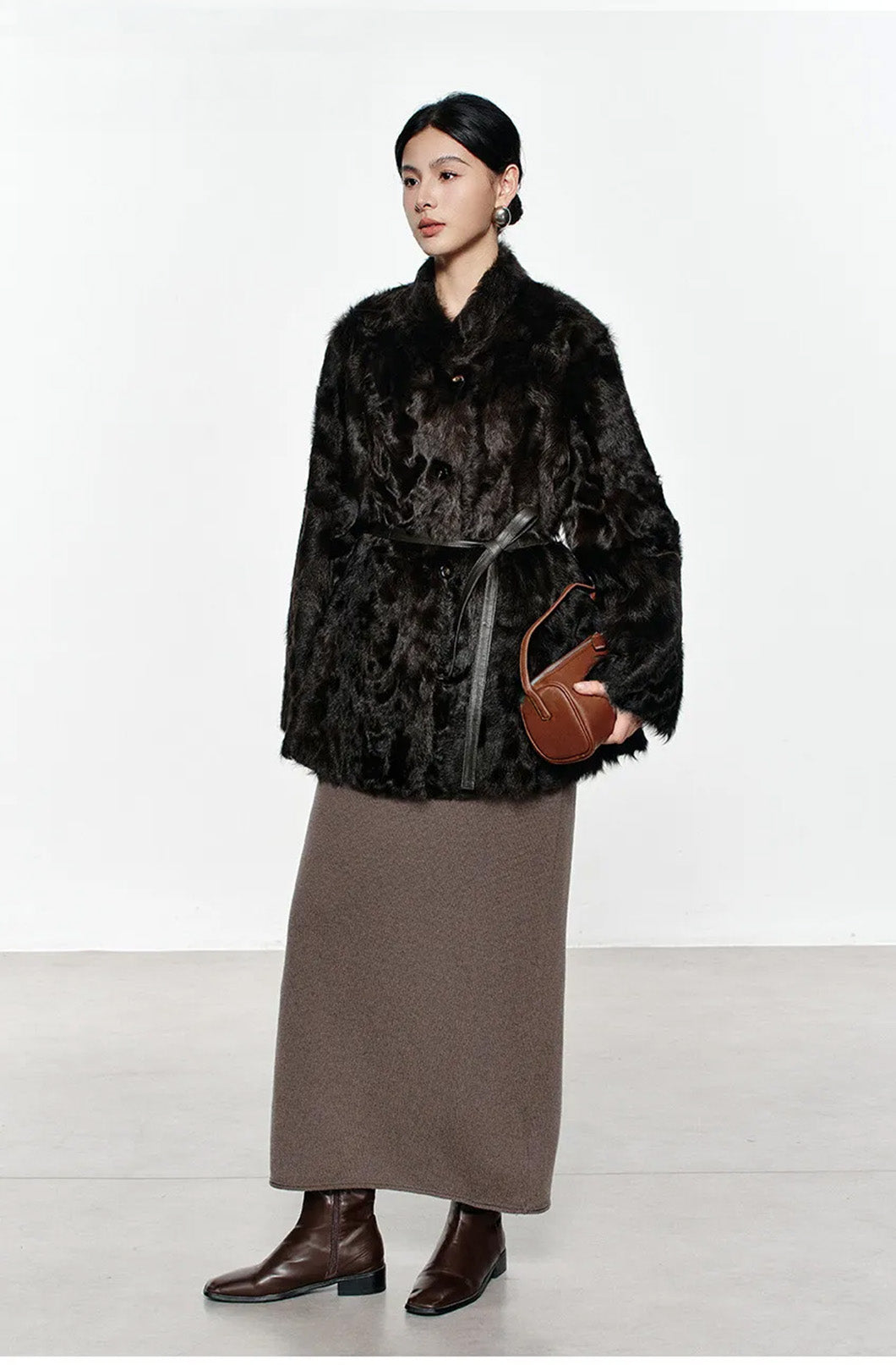 Model in Henna Glow V-neckline shearling coat turned slightly to the side, showing the coat’s fluid side profile — From Borcelleclothes.