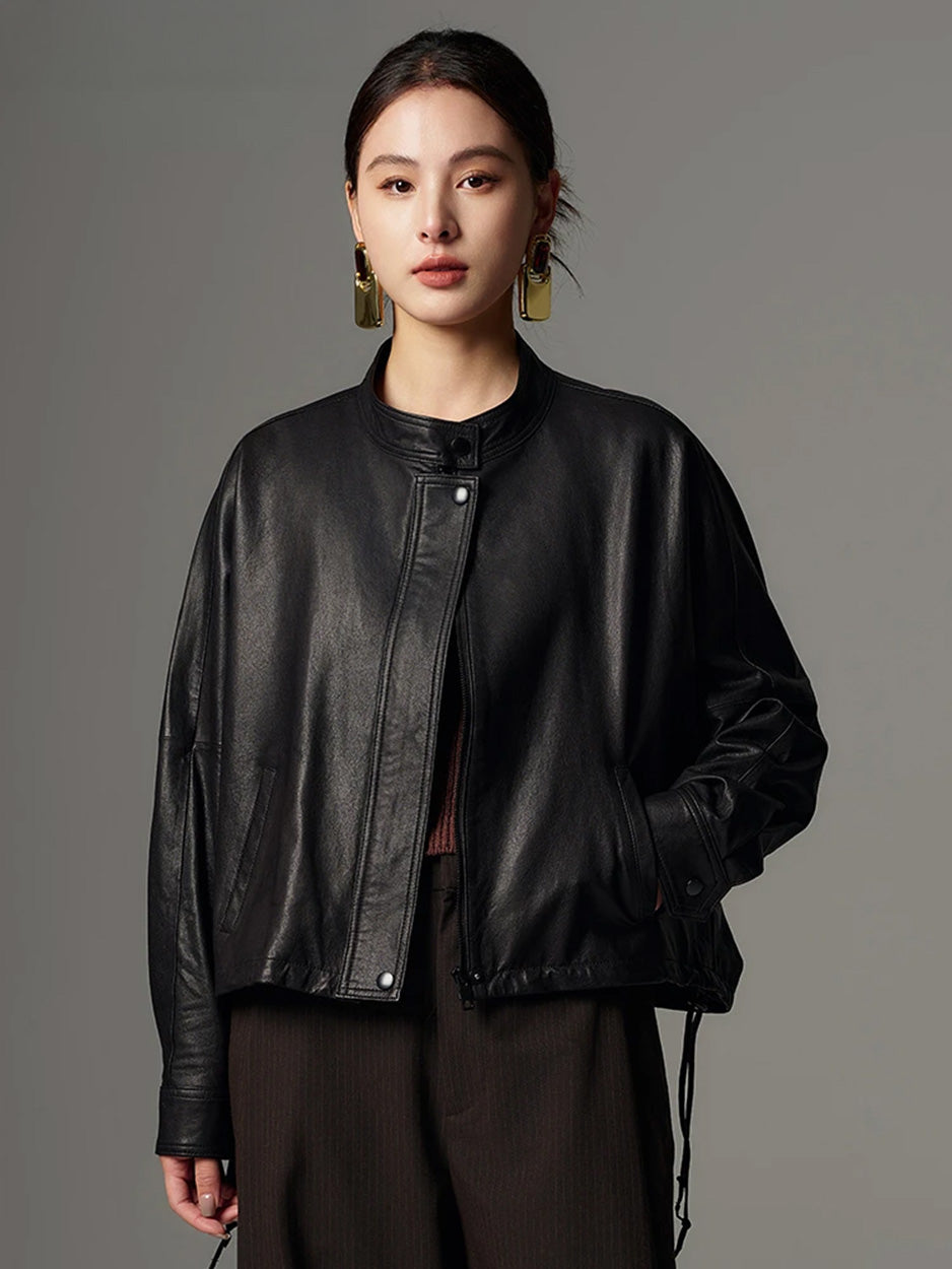 Front three-quarter view of the black leather jacket with the model resting her hand in the side single-welt pocket — From Borcelleclothes.