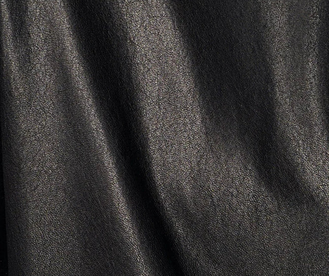 Close-up macro of the uncoated vegetable-tanned black sheepskin leather, showing natural fine grain and velvety texture — From Borcelleclothes.
