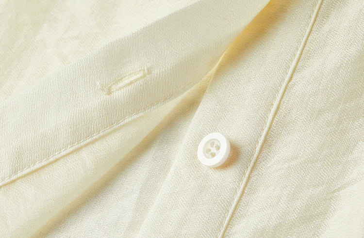 Detailed shot of the matching buttons on the semi-sheer elderflower fizz blouse — From Borcelleclothes.