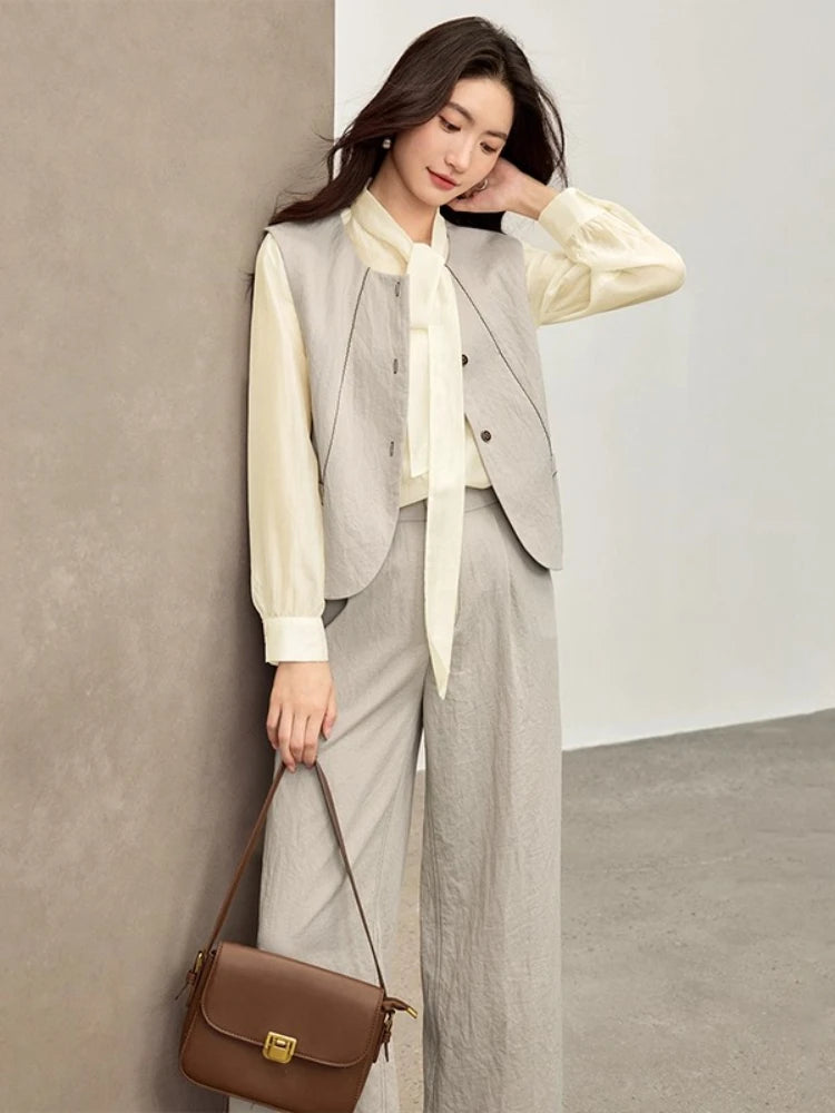 A woman in a velvet truffle viscose set gracefully adjusting her hair, highlighting the flow of the elderflower fizz blouse — From Borcelleclothes.