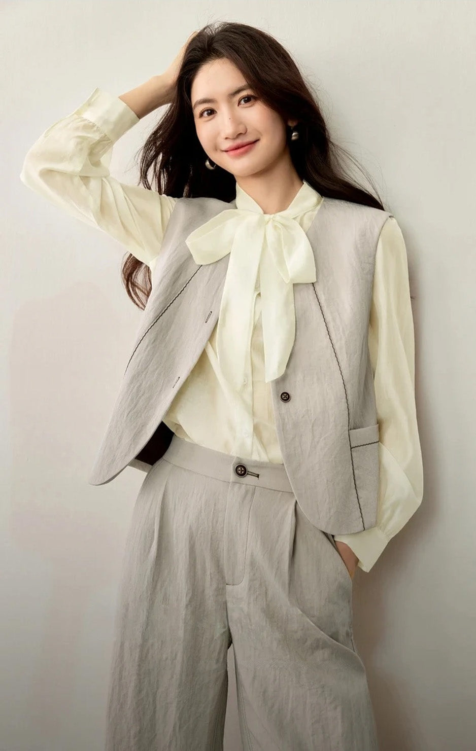 Effortless style: a woman with one hand in her trouser pocket, touching her hair with the other, wearing the full set — From Borcelleclothes.