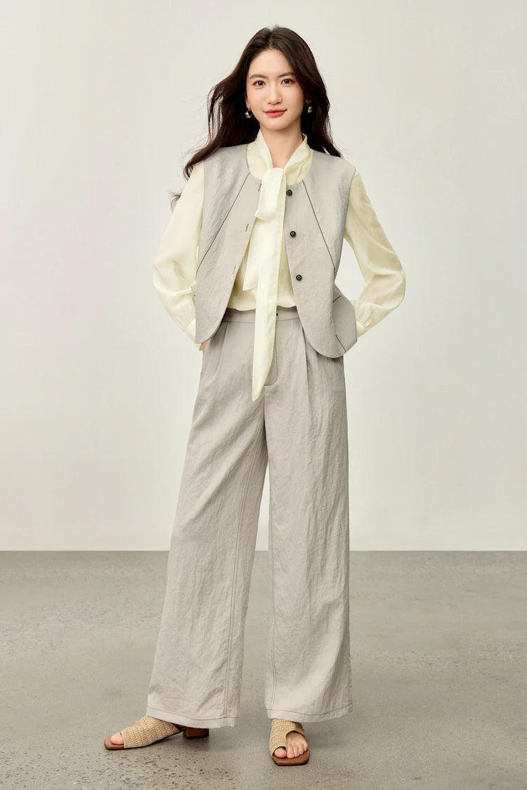 Confident posture: a woman in a truffle-toned three-piece set with hands on her hips, showing the structural fit — From Borcelleclothes.