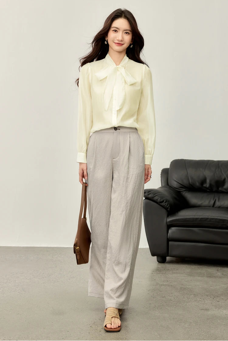 A woman wearing the elderflower fizz blouse alone, showcasing the lush, airy bow and gathered sleeves — From Borcelleclothes.