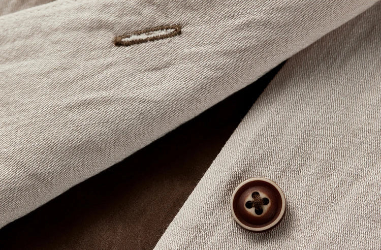 Macro shot of the contrast chocolate button on the unfastened truffle viscose vest — From Borcelleclothes.