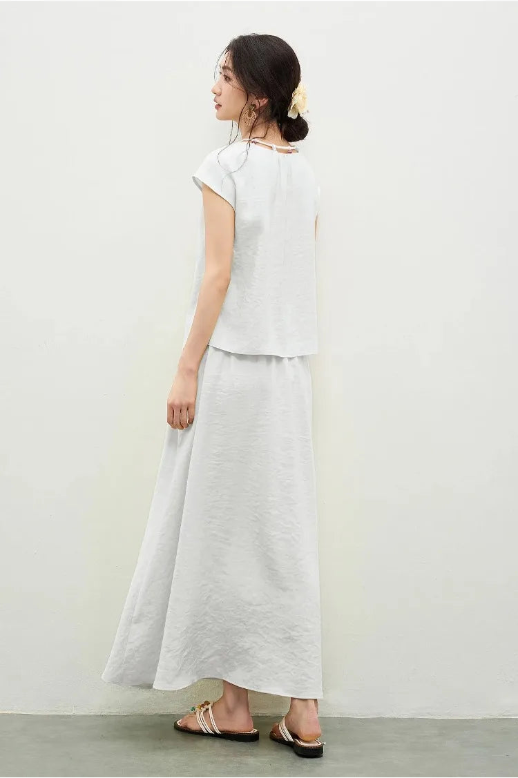 Back view of a woman wearing the white viscose set, showing the dropped shoulder silhouette and the flowing lines of the design — From Borcelleclothes.