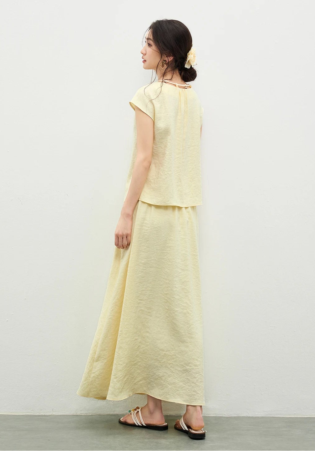 Back view of a woman wearing the yellow viscose set, showing the dropped shoulder silhouette and the flowing lines of the design — From Borcelleclothes.