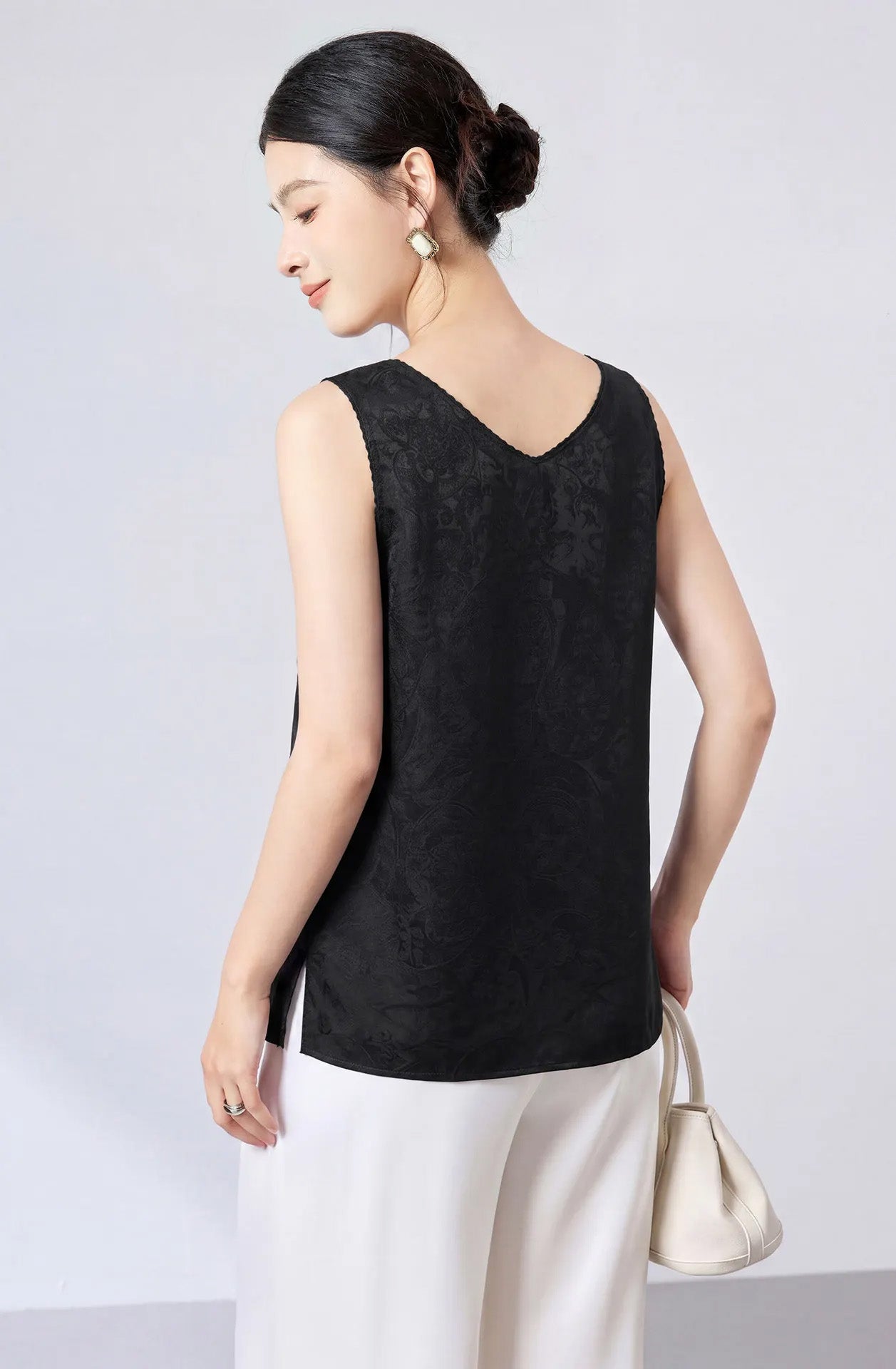 Back view of a model wearing a Freezing Twilight silk jacquard top featuring a deep V-neckline and fluid drape. — From Borcelleclothes.