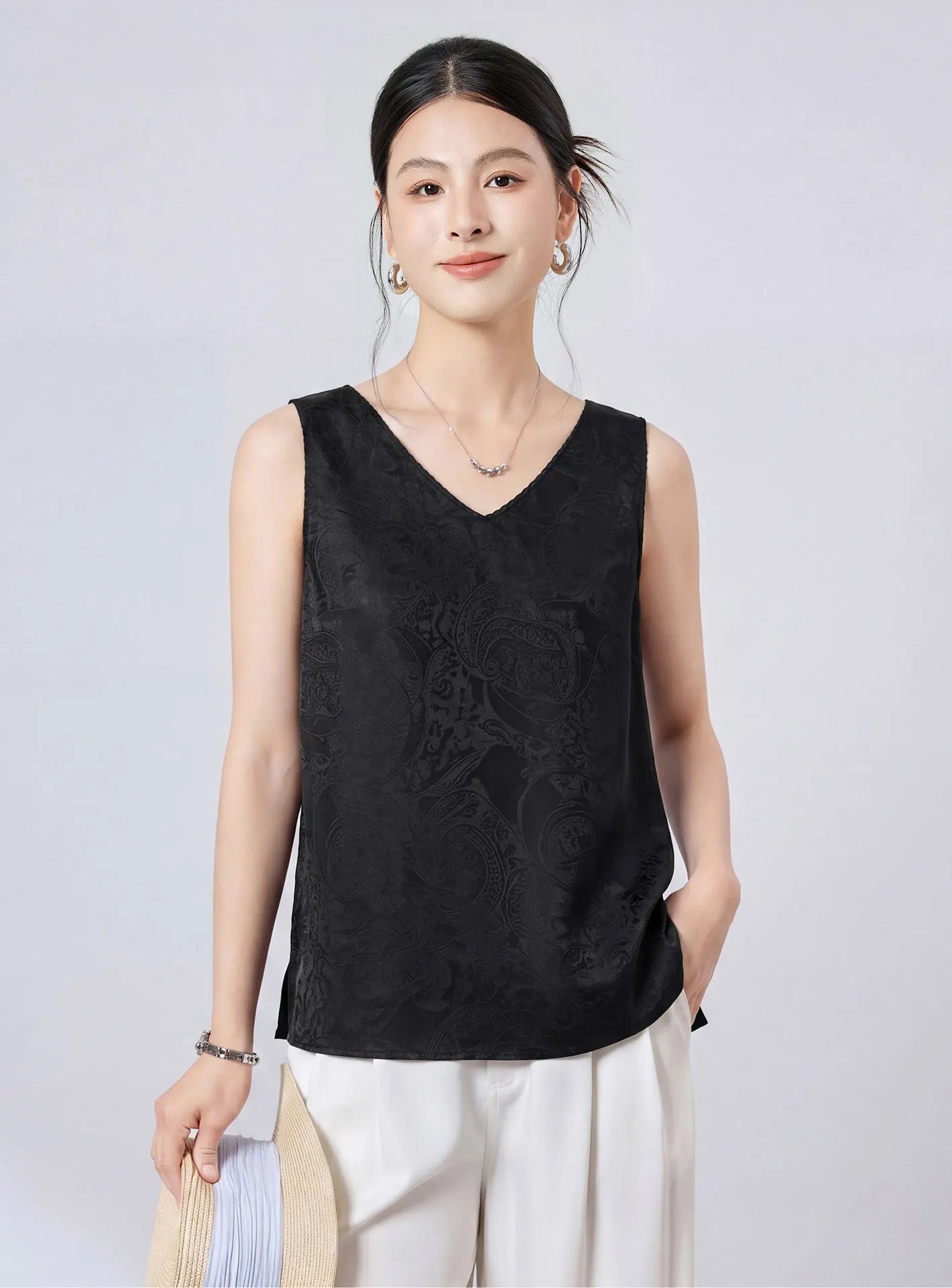 Model posing with a hand in her pocket in a relaxed Freezing Twilight viscose-silk jacquard sleeveless top. — From Borcelleclothes.