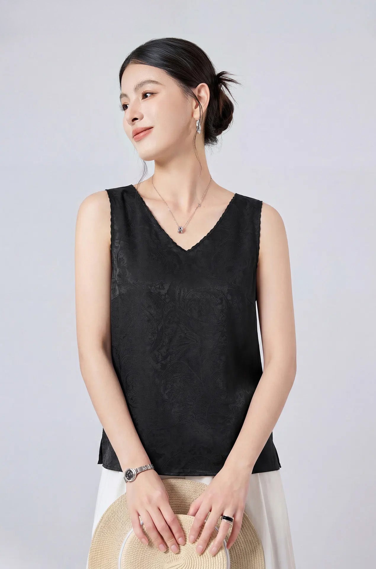 Model holding a straw hat wearing a Freezing Twilight viscose-silk jacquard sleeveless top with delicate picot trim. — From Borcelleclothes.