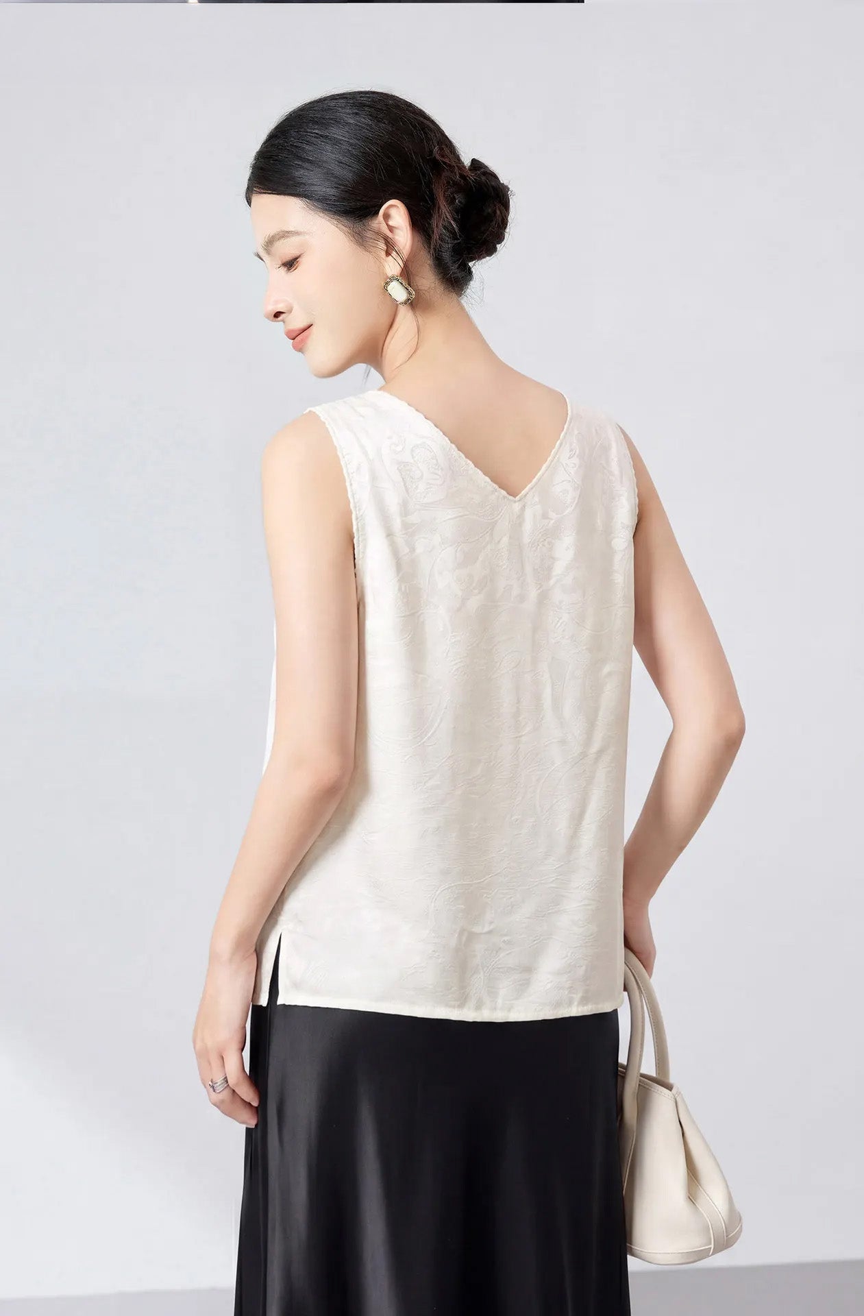 Rear view of a model wearing a Melting Ice Lace viscose-silk jacquard top with a graceful back V-neckline. — From Borcelleclothes.