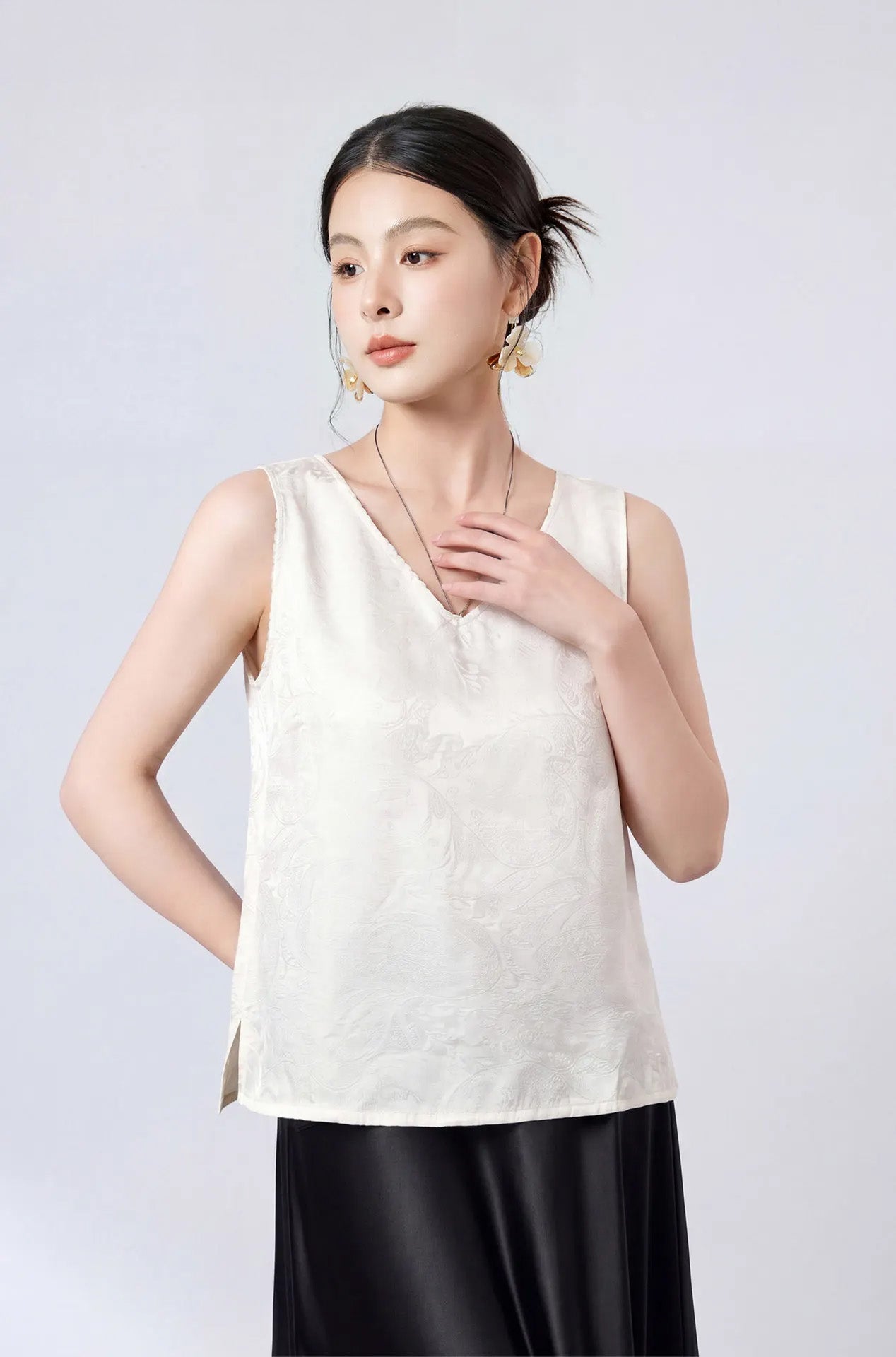 Detailed front portrait of a model highlighting the lustrous satin texture and picot V-neckline in Melting Ice Lace. — From Borcelleclothes.