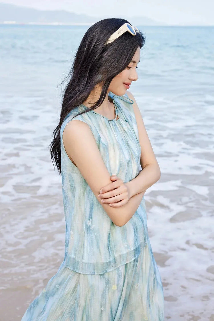 Profile view of a woman in an ethereal blue watercolor set highlighting the fluid drape of lyocell — From Borcelleclothes.