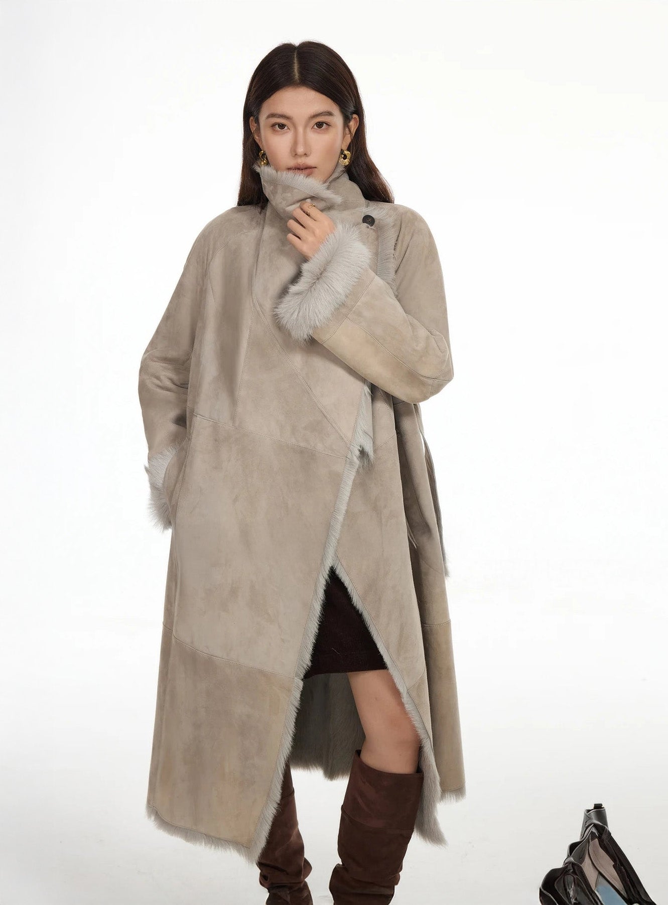 Model touching the fastened collar of the Neutral Intrigue coat, highlighting the voluminous lapel — From Borcelleclothes.