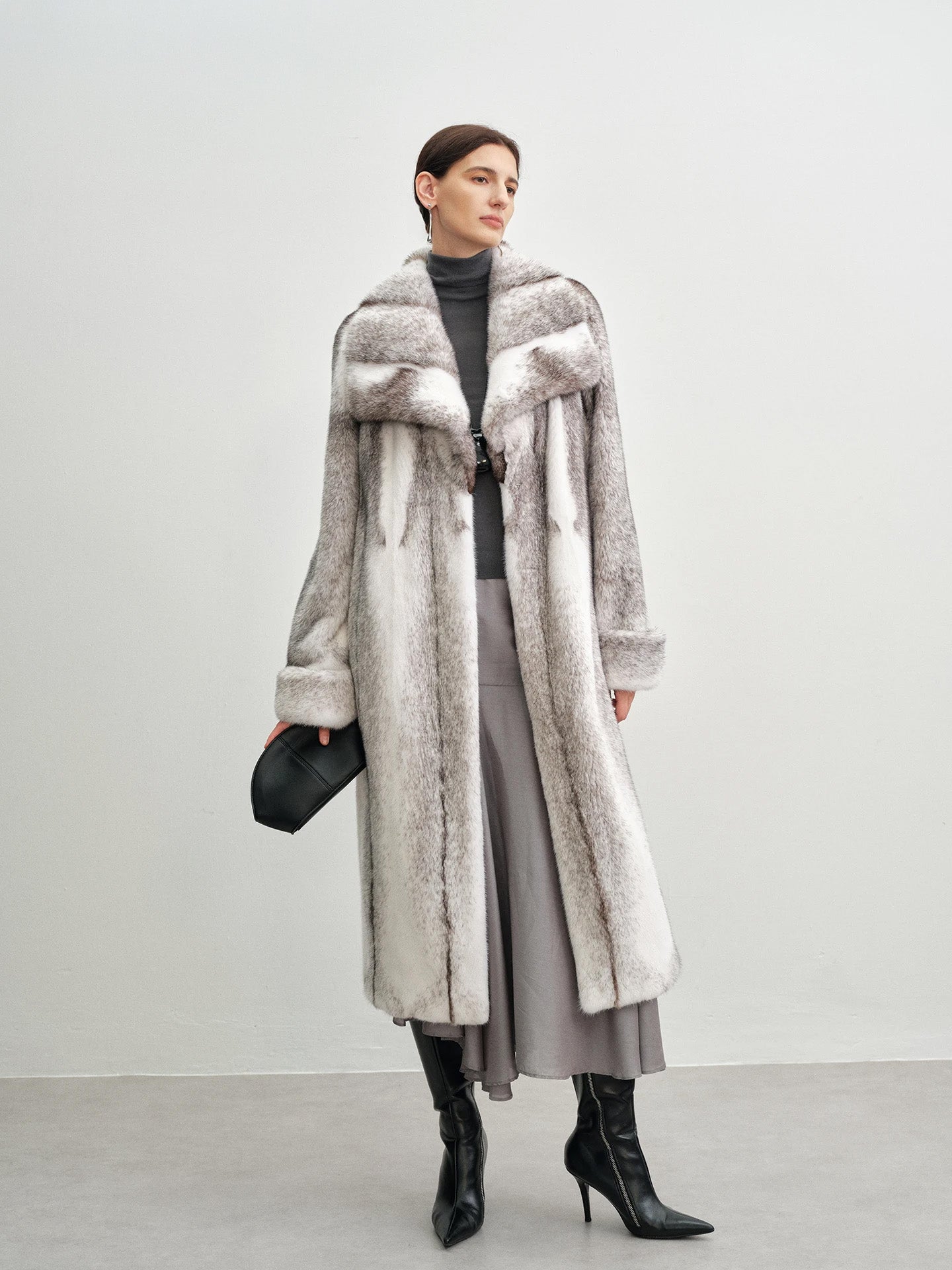 Model holding a small bag and looking to the side in the cross mink coat — From Borcelleclothes.