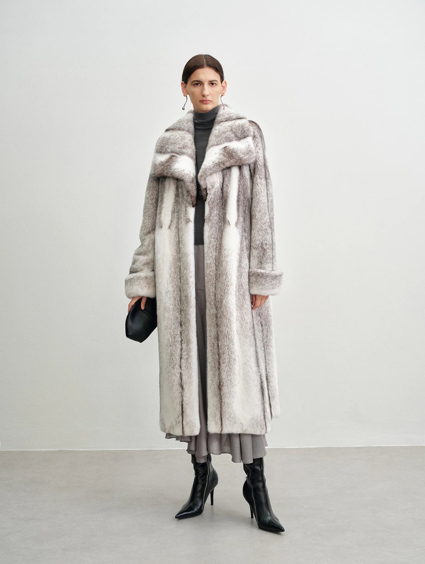Model holding a small handbag in the cross mink coat — From Borcelleclothes.