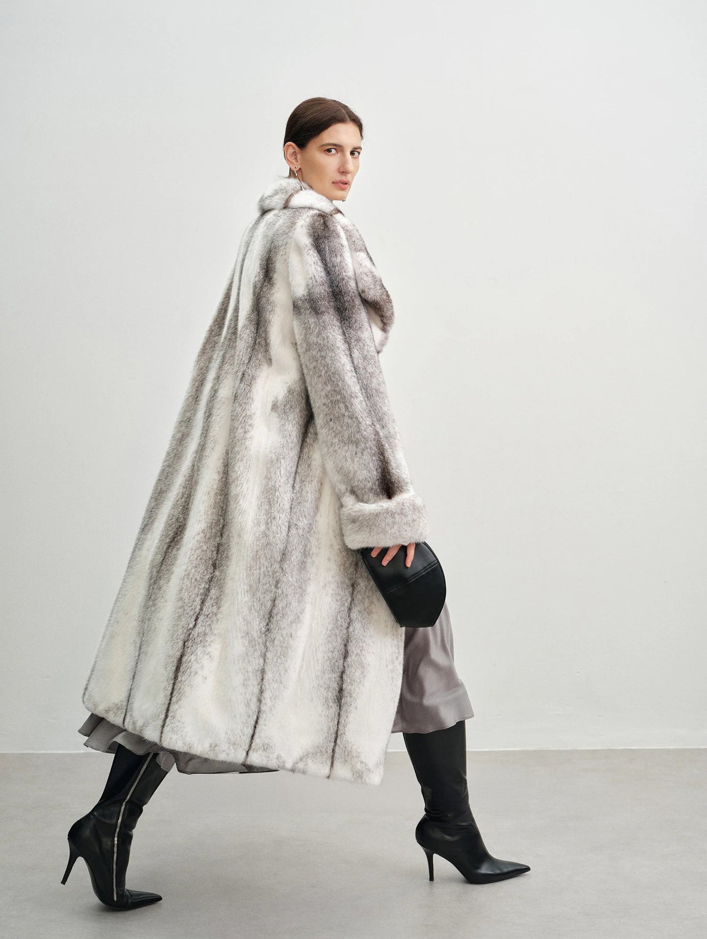 Model walking in profile wearing the cross mink coat — From Borcelleclothes.